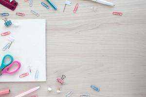 School office supplies on wooden background. Back to school concept. White board with hands for copy space. Top view ready for your design photo