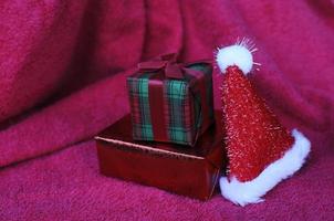 Cerca de la caja de regalo y decoración de gorro de navidad sobre fondos de alfombra roja foto