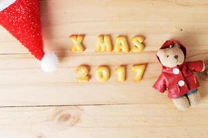 Christmas hat and bear decoration on wooden backgrounds above photo