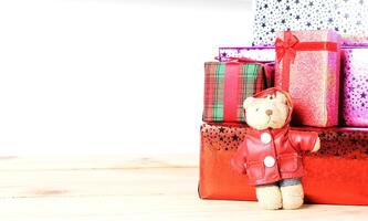 Teddy bear and gift box with wooden table on white backgrounds photo