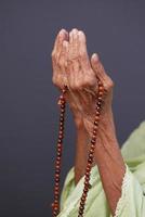 Cerca de la mano de las mujeres mayores orando en Ramadán foto