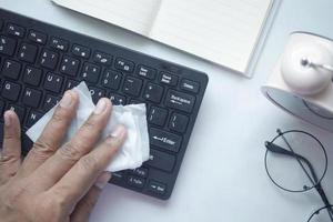 desinfectar el teclado con un pañuelo blanco en la mesa foto