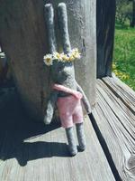 Rabbit toy in pink shorts with flower wreath photo