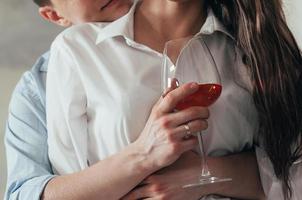 young couple embracing and drinking wine photo