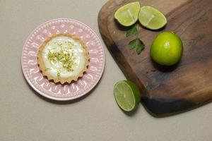 Vista superior de la tartaleta con crema de limón y chips de cítricos en la mesa de madera vieja, copie el espacio. enfoque selectivo. foto