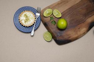 Vista superior de la tartaleta con crema de limón y chips de cítricos en la mesa de madera vieja, copie el espacio. enfoque selectivo. foto