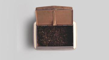 Raw tobacco in a box against white background.top up view photo