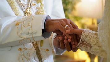 Cerca del apretón de manos del novio y la novia en la boda de Indonesia.