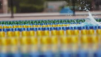 vista lateral de los nadadores en una piscina en cámara lenta