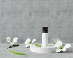 tubo de spray para medicamentos o cosméticos en un soporte circular y con flores.
