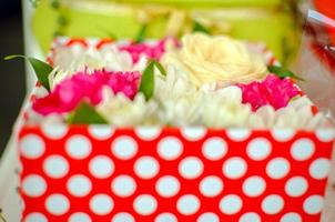 Hermoso ramo de flores mixtas de crisantemos, clavo y rosas en caja roja foto