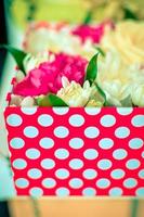 Beautiful bouquet of mixed flowers of chrysanthemums, cloves and roses in red box photo