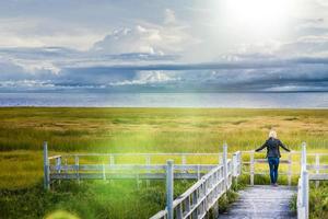 Lonely Young Woman Looking at the Amazing Calm Landscape from a Wood Balcony photo