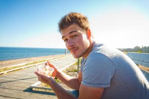 joven comiendo en la playa foto