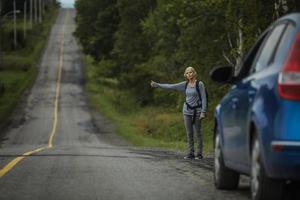 Blonde Woman Hitchhiking on the Side of the Road photo