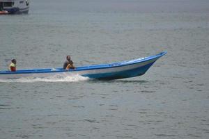 Sorong, West Papua, Indonesia, 2021. Villager crossing the sea with wooden boat. photo