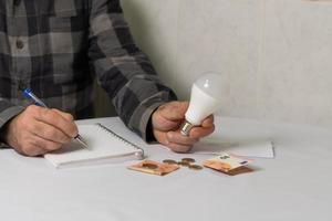 light bulb and money energy saving concept, electricity bill photo