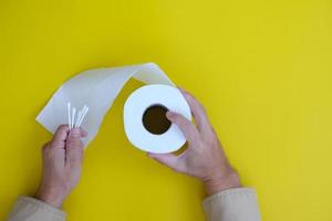 Toilet paper isolated on yellow background and healthcare concept