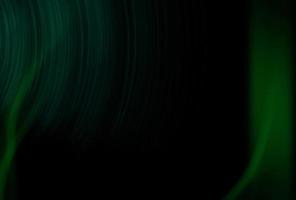 patrón de superposición verde claro de la llamarada del sol abstracto con textura brillante de los rayos abstractos en negro oscuro. foto
