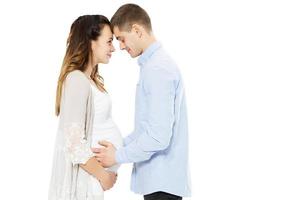 Young couple expecting baby standing together isolated on white background - baby born photo