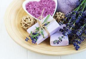 Heart-shaped bowl with sea salt, soap and fresh lavender flowers photo