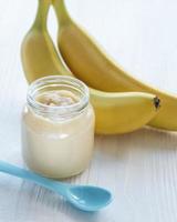 Jar of banana puree,  and bananas photo