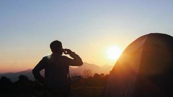 homem acampando esperando para ver o pôr do sol video