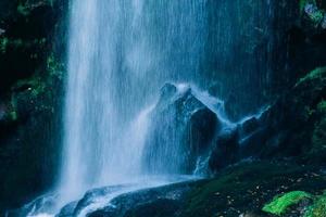 blue water beautiful waterfall in green forest and stone in jungle consist of water photo