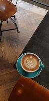 Leche de café con forma de corazón en una taza azul foto