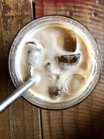 white coffee with ice cubes in a glass on the table photo
