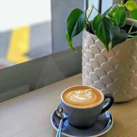 coffee milk with a tree shape in a clear white cup against a green background photo