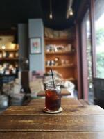 iced tea in a large glass with a straw with a cafe background photo