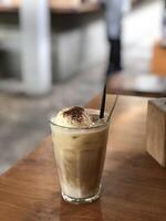 milk coffee with ice cream in a glass on the table photo