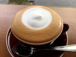 milk coffee with cream in the middle in a white cup photo
