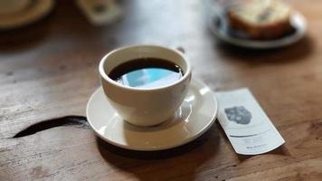 hot tea in a cup on a wooden table with paper photo
