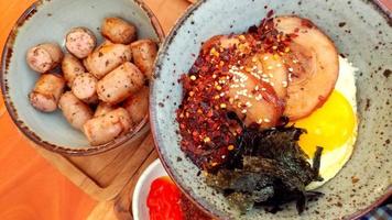 Japanese food contains sausages with egg and beef eyes and seaweed in a container photo