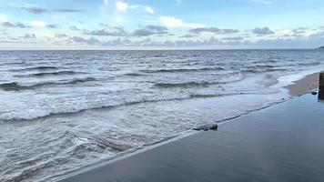 Sea waves are curling into an arch form and breaking on the shore. video