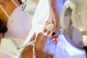 Beautician giving a pedicure painting her client's nails in a beauty centre. photo