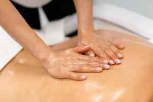 Woman receiving a back massage with massage candle oil.