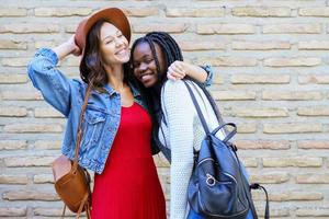 Two friends hugging in urban background. . Multiethnic friends. photo