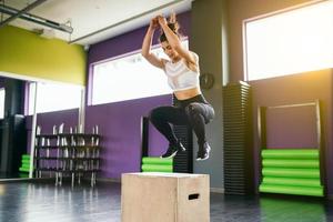 fitness mujer saltando sobre una caja como parte de la rutina de ejercicios. foto