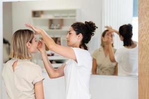 Arab makeup artist making up a woman in a beauty center. photo