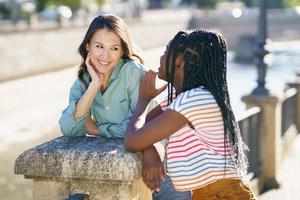 Two Multiethnic women talking together on the street. photo