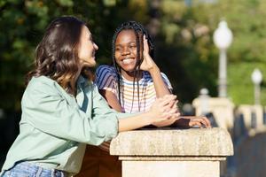 dos mujeres multiétnicas hablando juntas en la calle. foto