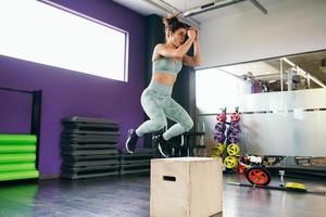 fitness mujer saltando sobre una caja como parte de la rutina de ejercicios. foto