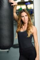 Entrenador personal femenino con saco de boxeo en un gimnasio foto