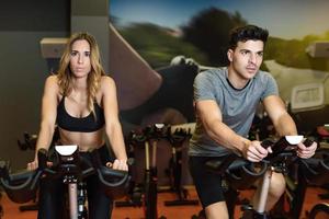 pareja en una clase de spinning vistiendo ropa deportiva. foto