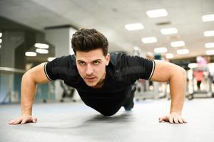 Attractive man doin pushups in the gym photo