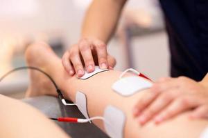 Electro stimulation in physical therapy to a young woman photo