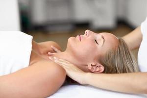 Young woman receiving a head massage in a spa center. photo